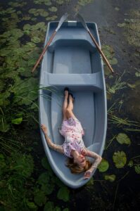lady lying in a boat on the river relaxing